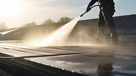Worker pressure washing a roof
