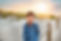 a young boy is smiling mischievously on a beach