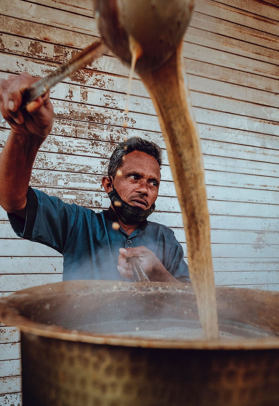 Chai wala tea seller Mumbai India action shot making tea street portrait