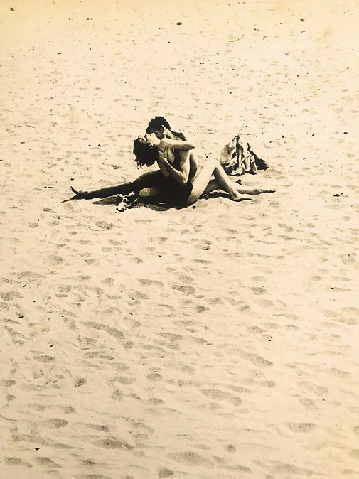Coney Island lovers hug eachother, sitting on on sand