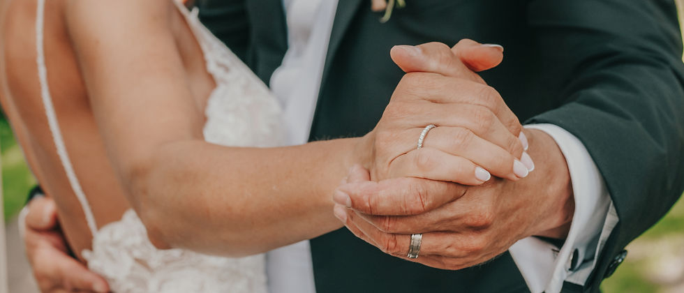 Close-up of a married couple holding hands while dancing