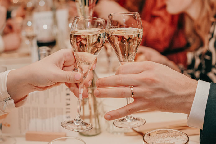 Close‑up of champagne glasses clinking in a toast during a Cyprus wedding celebration.