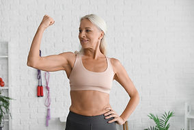 Body positive mature woman showing muscles in gym.jpg
