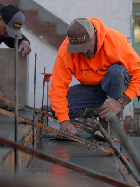 two men smooth freshly poured concrete stairs