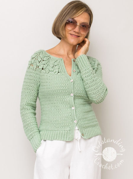 Handmade crochet cardigan worked top-down, featuring a round yoke with intricate embossed leaf and berry textures. Button-front design available with either long or short sleeves, finished with ribbed bands or herringbone stitch edging.