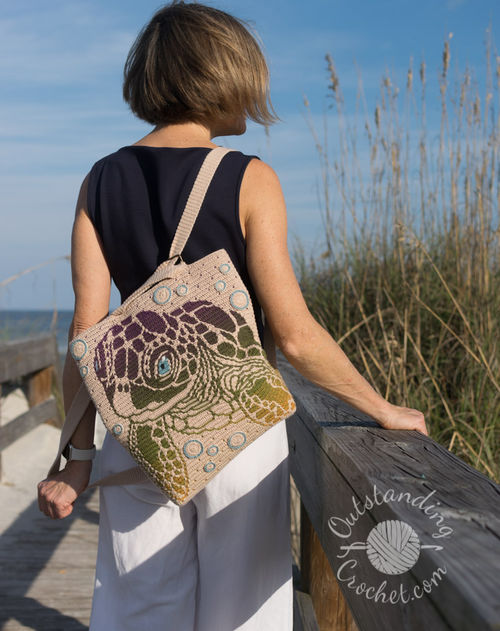 Crochet turtle bag or pillow featuring a realistic baby turtle swimming in water, surrounded by coral and bubbles.