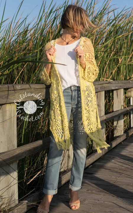 Garden Bohemia women summer lace robe cardigan crochet pattern in floral lace stitch, with long sleeves, an open front, and knotted fringe edging at the bottom. 