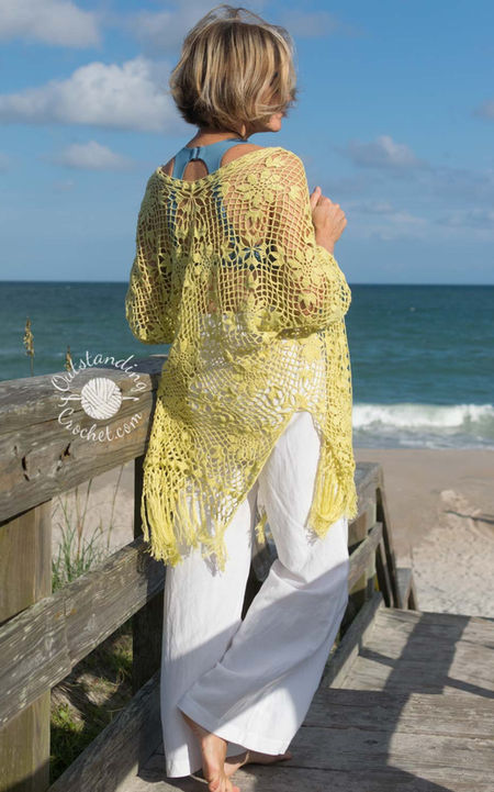 Garden Bohemia women summer lace robe cardigan crochet pattern in floral lace stitch, with long sleeves, an open front, and knotted fringe edging at the bottom. 