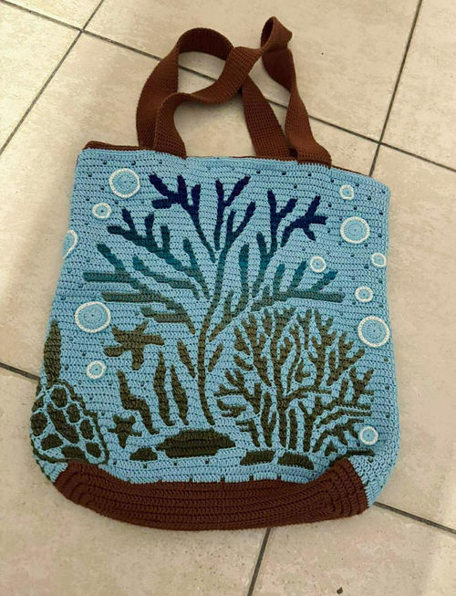 Crochet turtle bag or pillow featuring a realistic baby turtle swimming in water, surrounded by coral and bubbles.