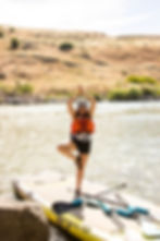 White water rafting on the snake river. Standing on mega paddle board doing aa yoga pose.