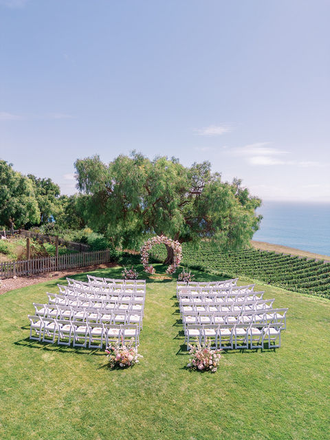 bird eye view of A fine art wedding ceremony with neutral colors and romantic flowers over Palos Verdes coastal background at Catalina View Gardens