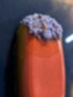 Orange ice cream bar with purple sprinkle topping