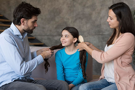 parents-brushing-daughter-hair.jpg