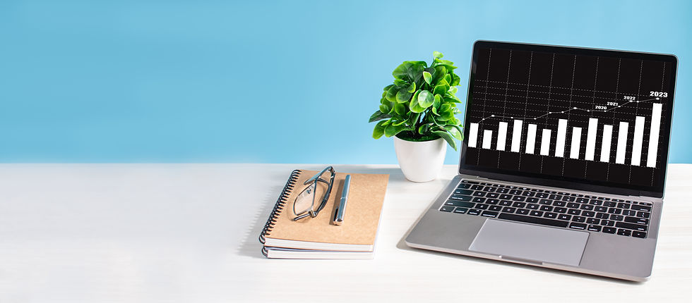 Laptop on a desk with a potted plant, notebook, glasses, and pen, representing business planning and market entry strategy