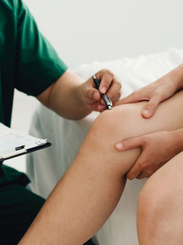 Patient having knee examined by doctor.