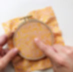 finger tapping the fabric inside an embroidery hoop