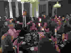 Close-Up illusionist performs some rope illusions for a group around a table at a dinner event