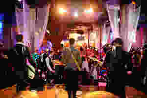rock band with 3 guitarists and bass players performing on stage at a wedding party