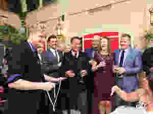 magician in a black and purple suit performs some close up rope magic tricks and illusions in front of a group of people