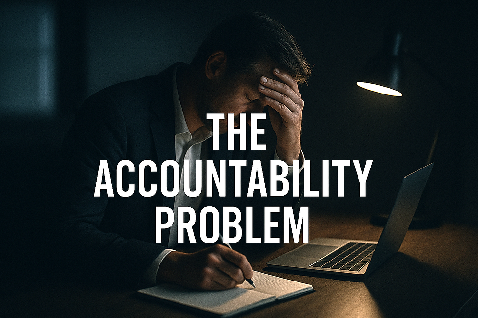 Business professional at desk holding his forehead while riding beside a laptop, representing the accountability problem.