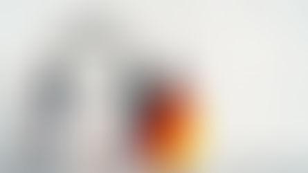 Kitapların üzerinde kulaklık bulunan bir çalışma düzeni ve yanında Almanya bayrağı; Almanca öğrenimi ve sağlık çalışanları için dil gelişimini temsil eden eğitim ortamı.