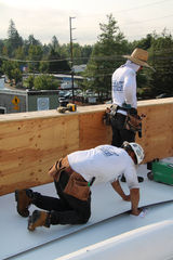 Professional roofer installing asphalt shingles during a residential roof replacement in Portland, Oregon.