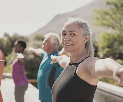 People stretching together with a woman looking at the camera and smiling