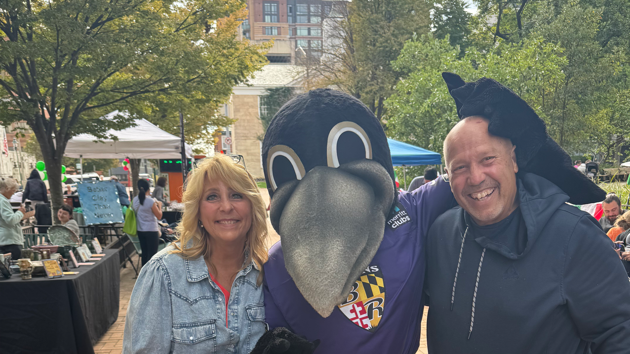 Owners of Woody's Goodies pose with Ravens Mascot Poe