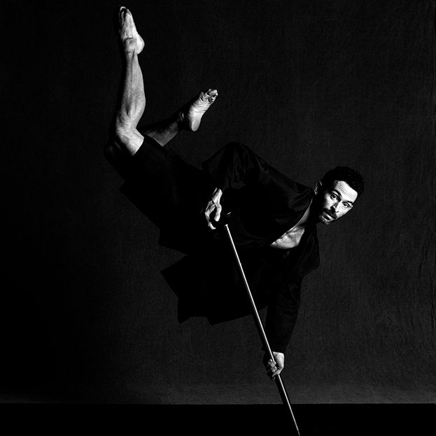 Portrait noir et blanc d'un homme en pose d'équilibre acrobatique