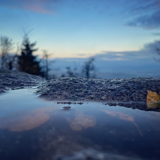 Wasserspiegelung in einer Pfütze auf dem Felsen.