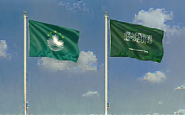 Macau flag and Saudi Arabia flag flying together under a clear daytime sky representing e-visa access.