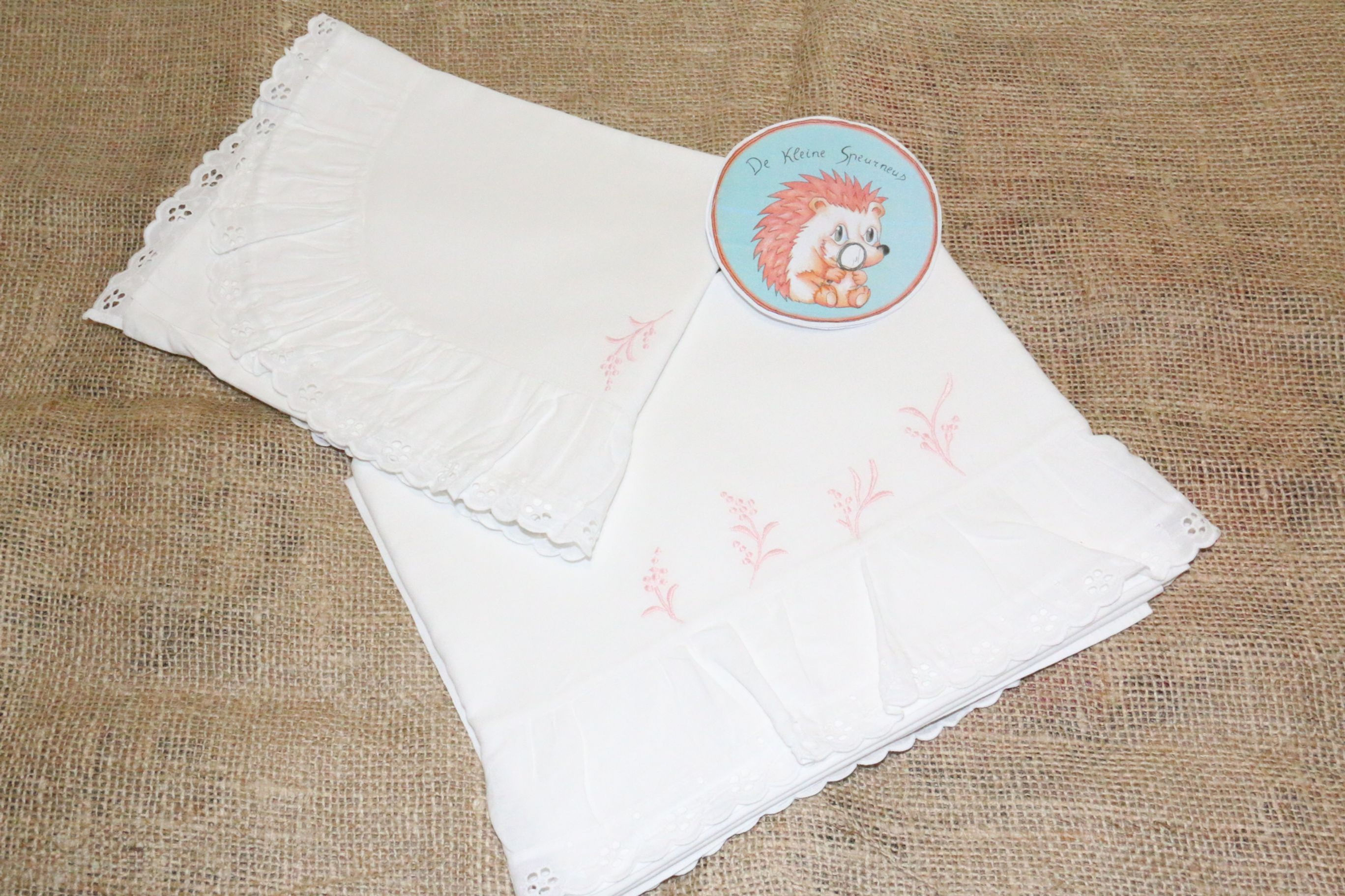 wit lakentje met kussensloop  roze geborduurd bloempje