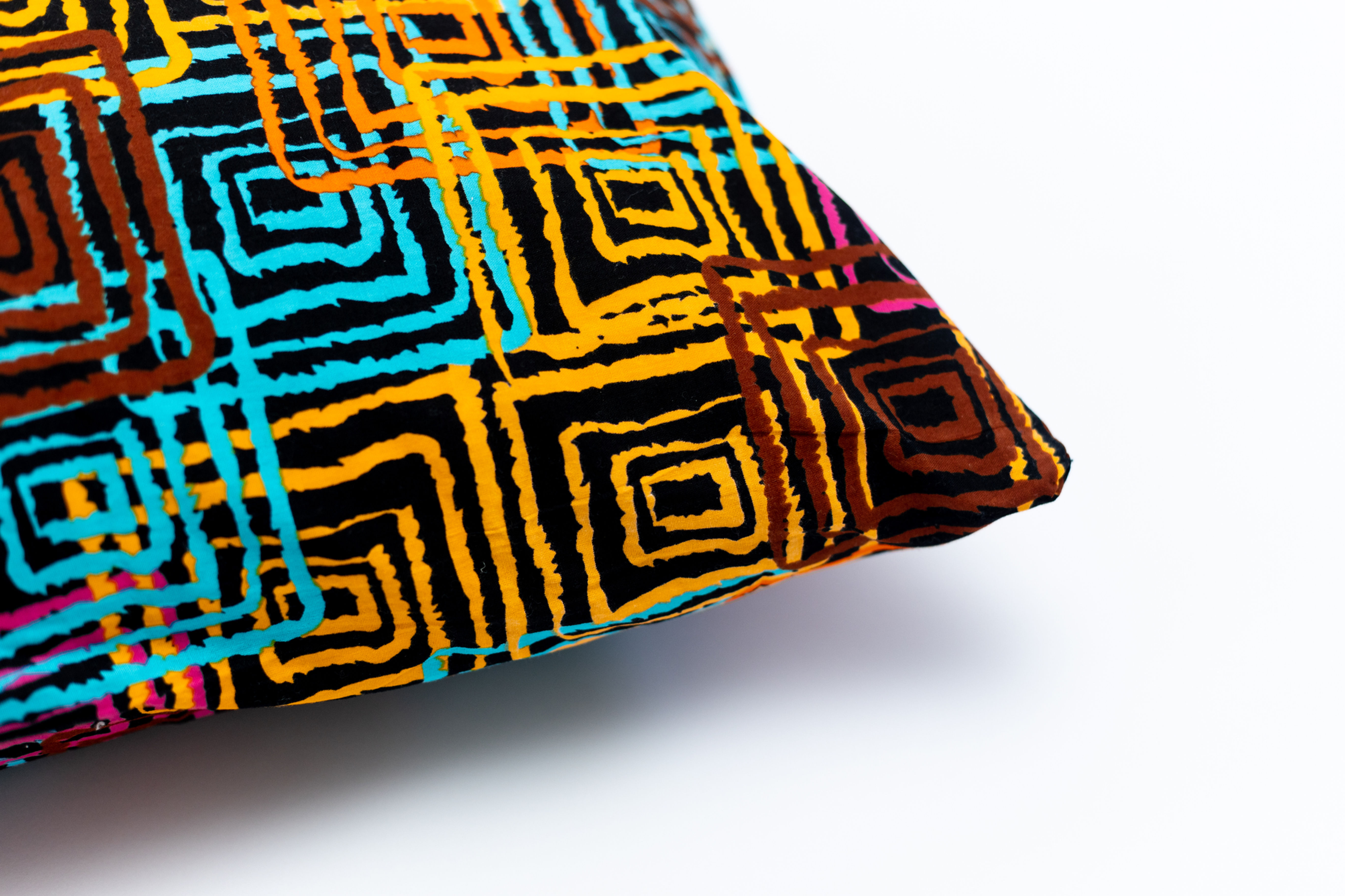 Cotton cushion cover with colorful maze squares in brown, pink, blue, yellow, and orange on black