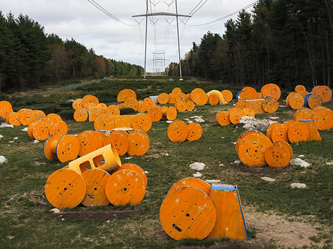 blue and orange wire reels underneath powerlines at high voltage paintball powerline