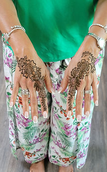 Simple floral henna design on both hands featuring bold blooms, paisley accents, and delicate finger detailing by Isha’s Henn