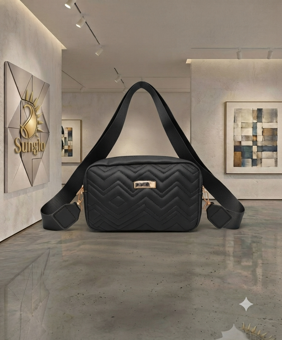 Black quilted ladies bag with wide strap in a gallery.