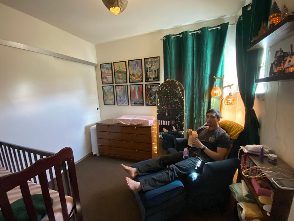 Author's husband sitting in nursery on glider holding boxes
