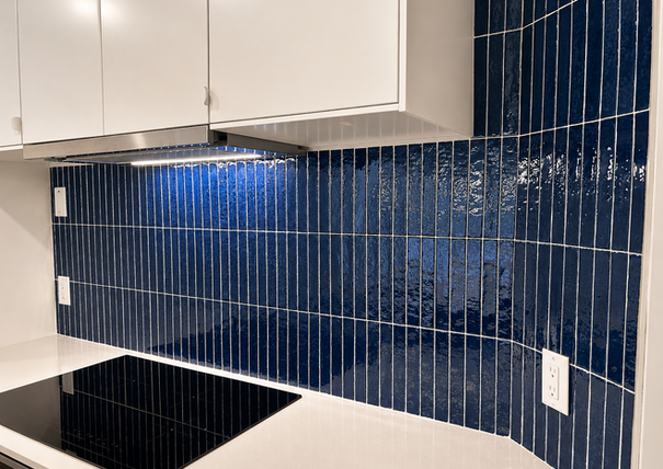 Dosseret bleu et plaque de cuisson dans une cuisine rénovée à Brossard