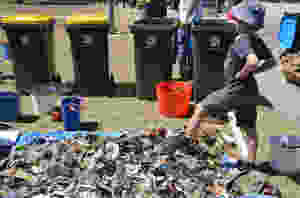 Boy standing over rubbish collected from the Port River, Adelaide