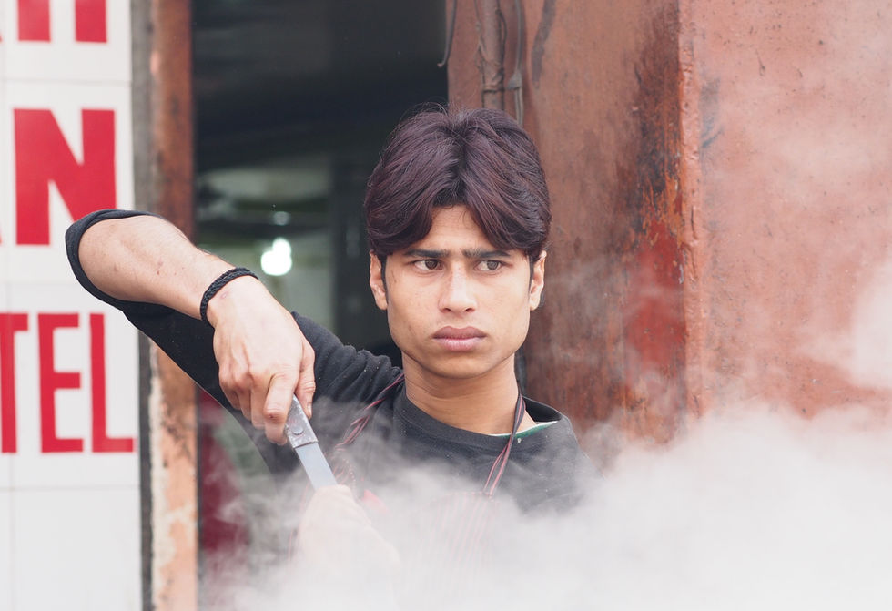 a young man is holding a pair of scissors and looking at the camera
