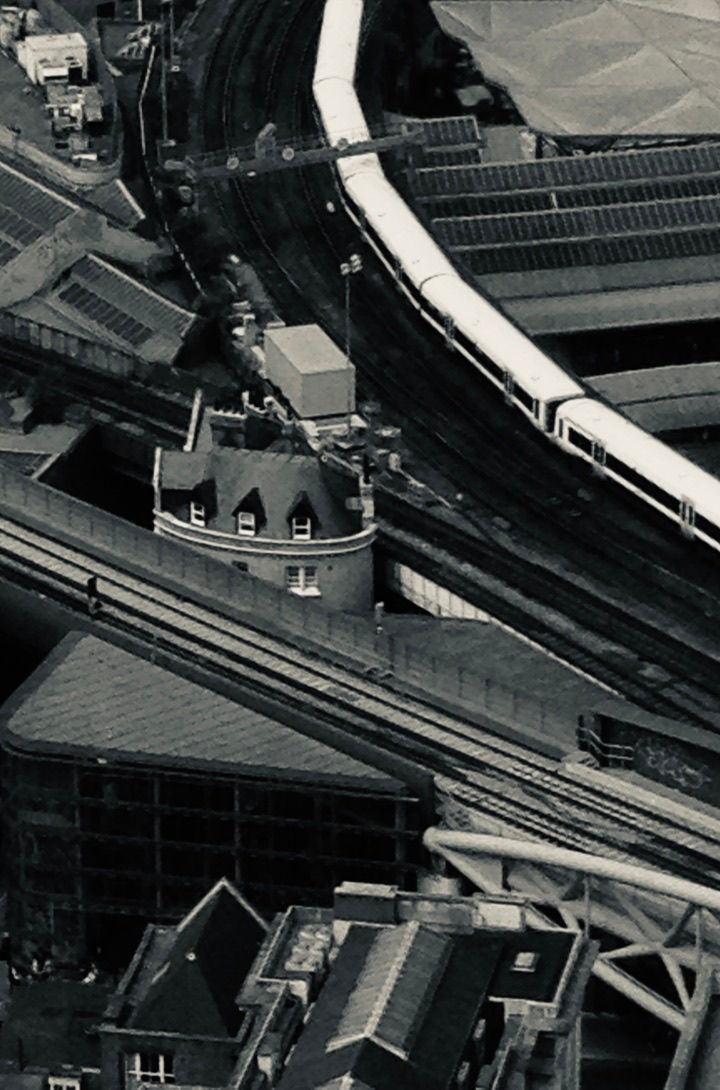 a black and white photo of a train going down the tracks
