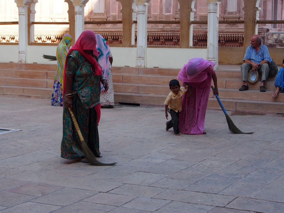 a woman in a pink dress is sweeping the floor with a broom