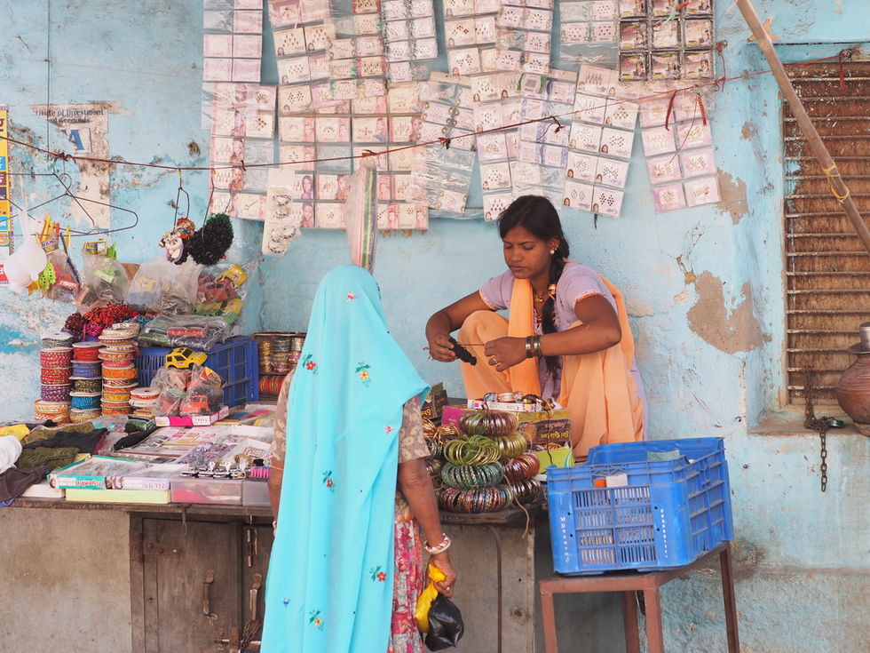a woman sits in front of a display of earrings and bracelets