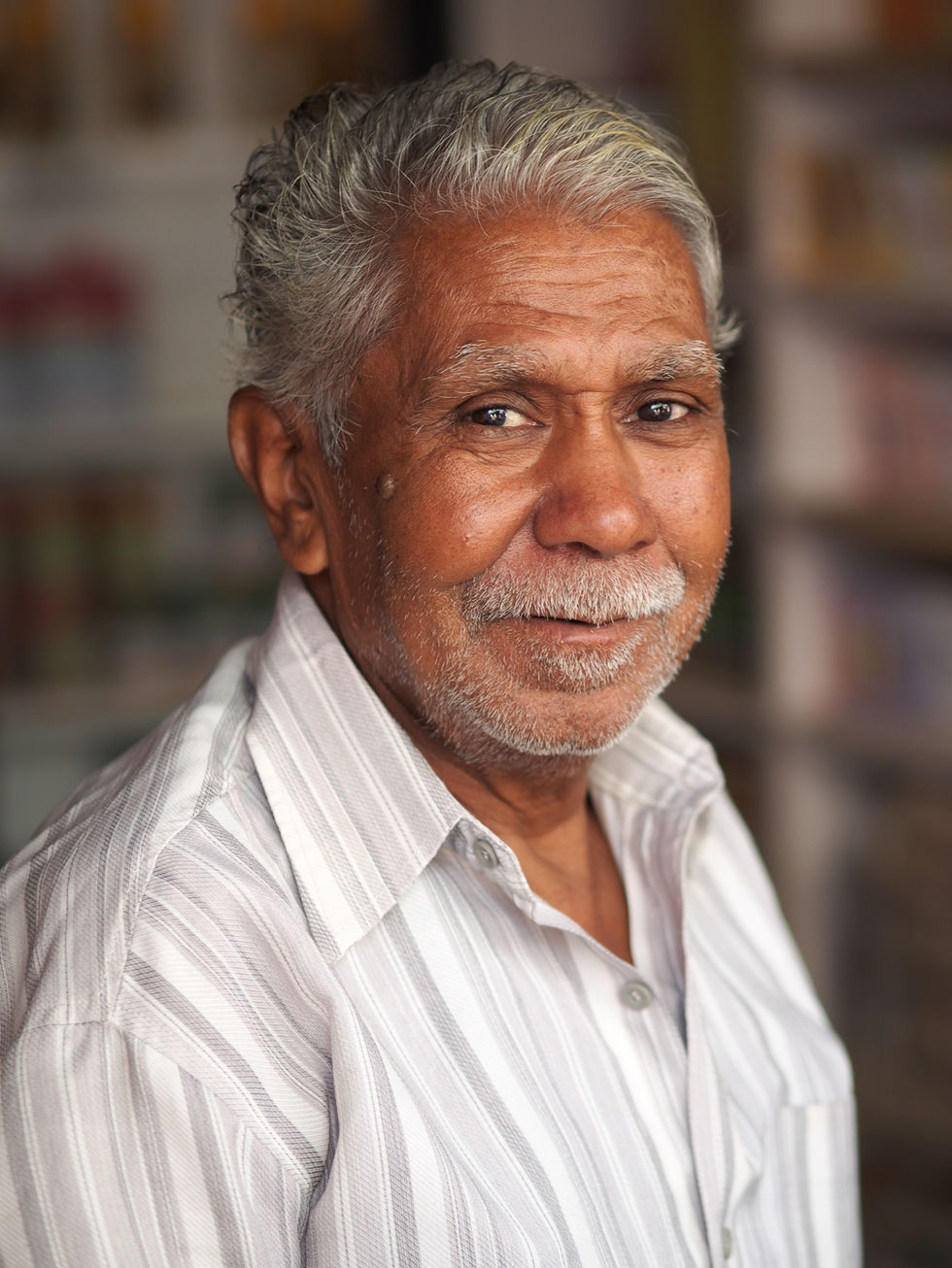 a man with gray hair and a beard smiles for the camera