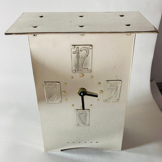 Sterling silver clock case front showing 18ct gold rivets to mark hors.