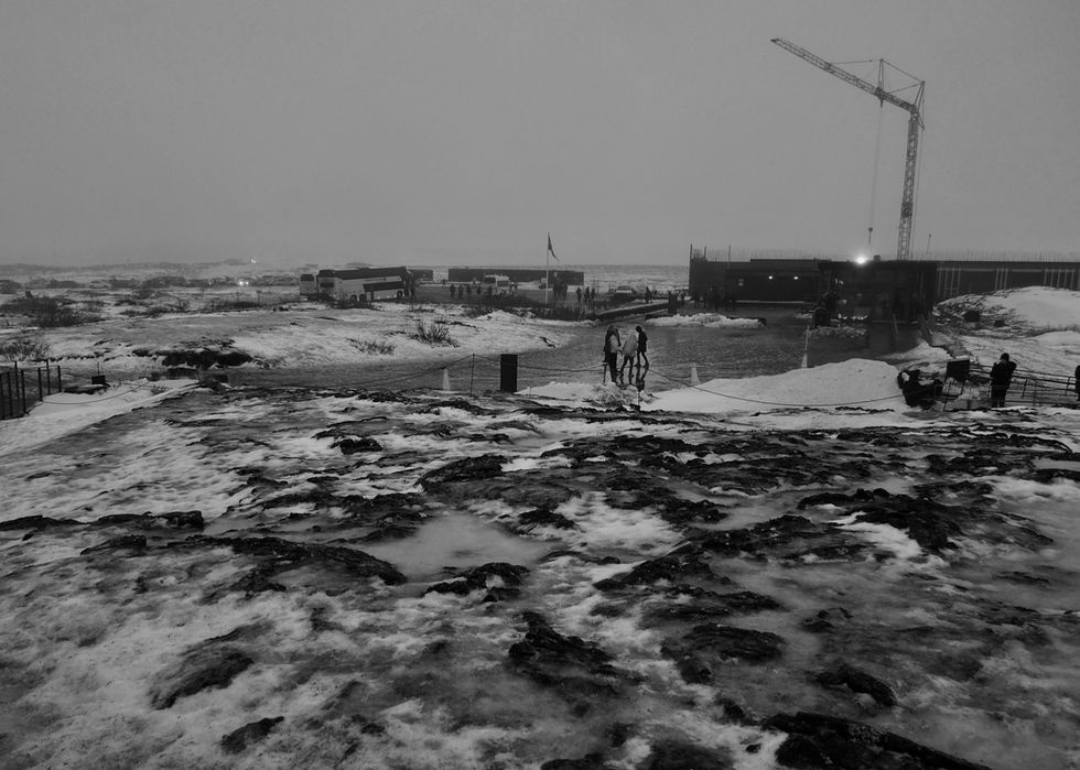 a black and white photo of people standing in the snow