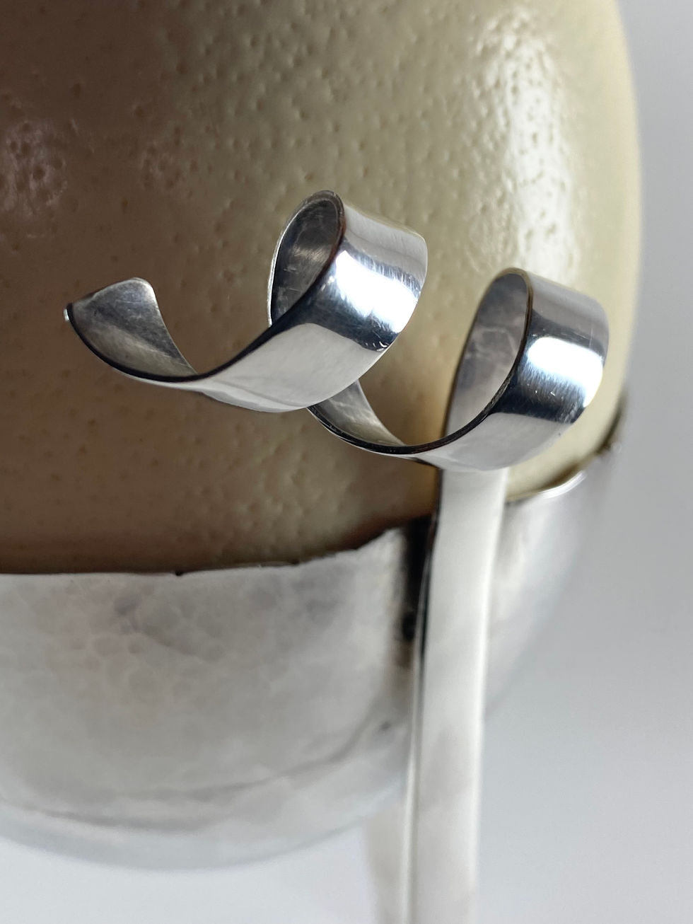 Sterling silver egg cup for an ostrich egg. Bowl hand raised with three legs rising to spirals. Silversmith David Salariya, silver maker,
hand-crafted silver, bespoke silver items, silver artisan, silver workshop.