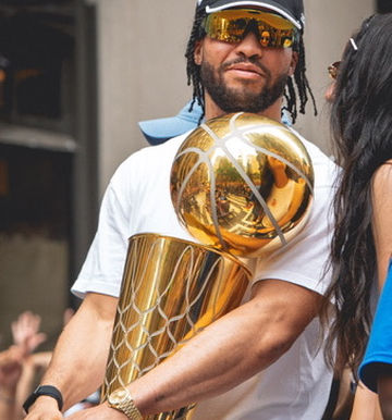 Jaylen Brunson holding the NBA Championship trophy in New York City during the NY Knicks championship parade