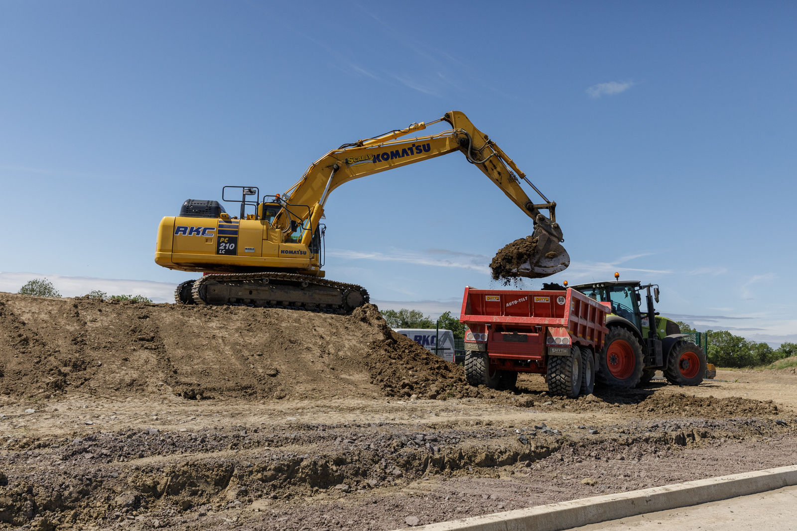 RKC Komatsu excavator loading a dump trailer