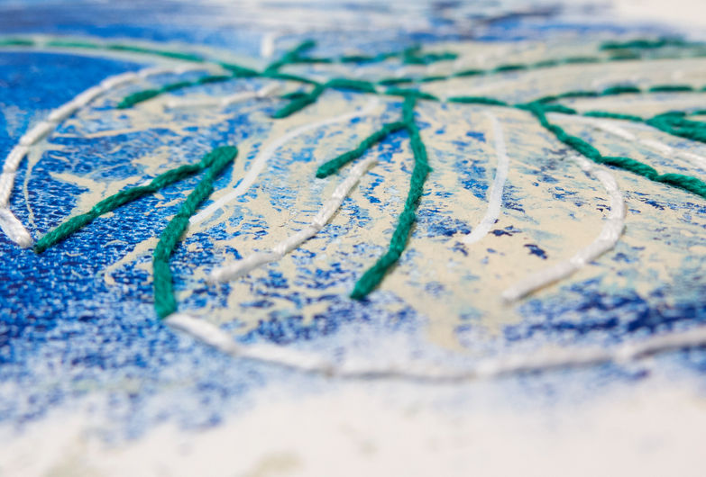Detalhe de uma obra feita com monotipia sobre papel, com intervenção em bordado, destacando a textura da impressão e o relevo do bordado. A paleta de cores traz azul médio, verde escuro, bege e branco. 